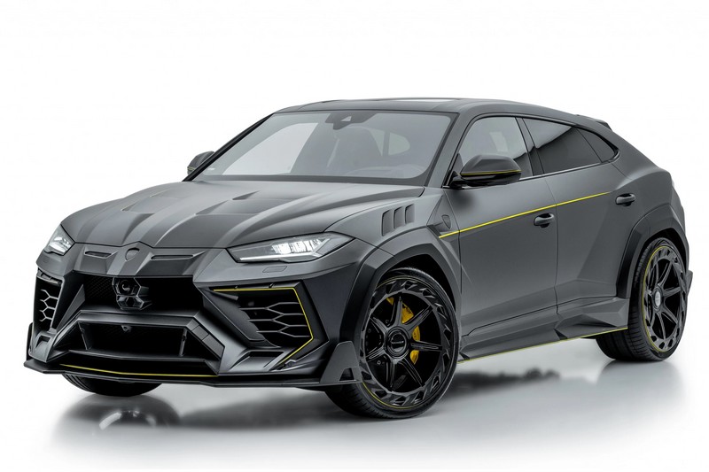 The image shows a black Lamborghini Urus parked in a modern city environment. The SUV has sharp, aggressive lines and a bold front grille. Large air intakes and sporty black alloy wheels enhance its powerful appearance. The glossy black paint reflects the surroundings, giving the vehicle a luxurious and dominant look.